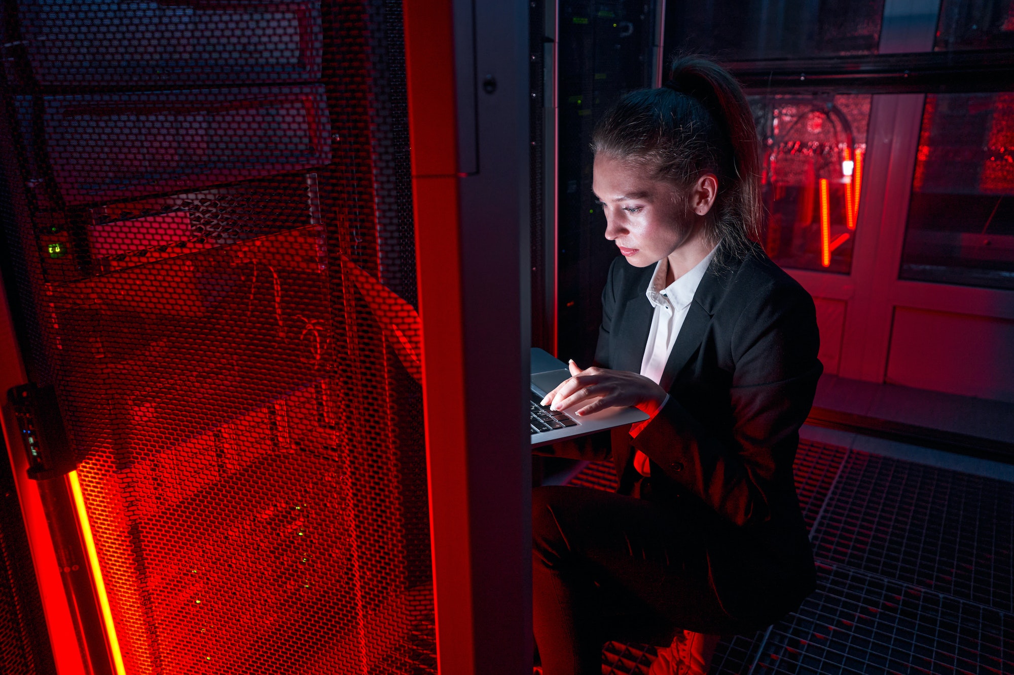 Smart woman working at servers in data center